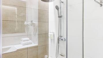 A modern shower with a handheld showerhead and a wall-mounted faucet.