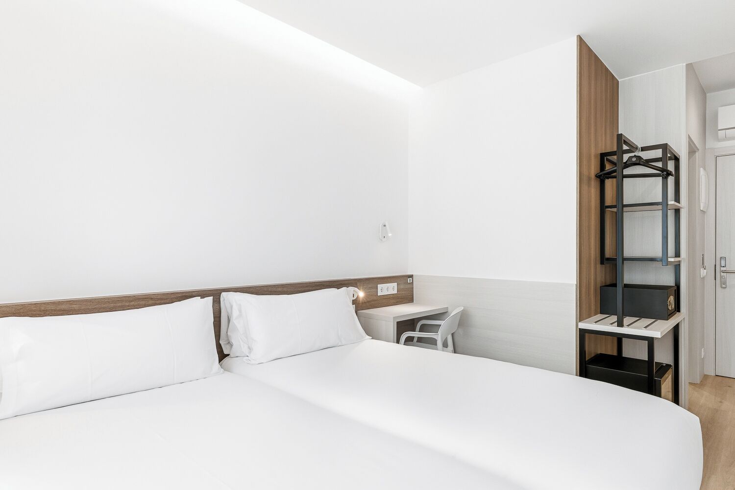 Una habitación de hotel con cama, escritorio y armario.