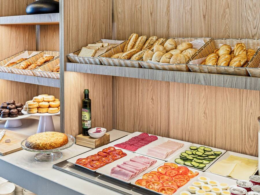En buffet med forskellige spiser, blandt andet brød, kager, kød og grøntsager.