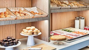 Un bufé con pasteles, una variedad de quesos y embutidos.