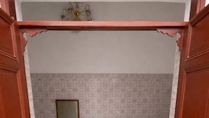 Een slaapkamer met een bed, een kaptafel, een spiegel en een kroonluchter.