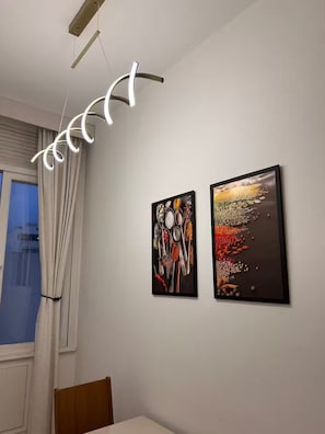 A room with a dining table, two framed artworks on the wall, and a modern light fixture. - Top apartment 350m from Copacabana beach (Rio de Janeiro)