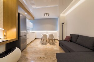 Eine moderne Küche mit Essbereich, einer Couch und einer Stehlampe.