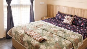 A bedroom with a bed, curtains, an air conditioning unit, and a ceiling fan.