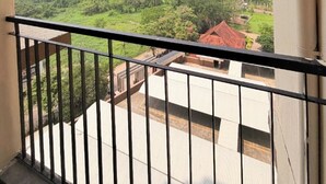 A balcony with a view of high-rise buildings and greenery.