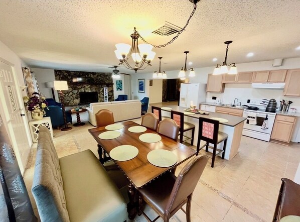 A spacious living area with a dining table, kitchen, and seating arrangements. - 4 bedroom pool house located in a bird sanctuary (Hudson)