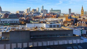 Een stadsgezicht met een mix van moderne en historische gebouwen, waaronder een opvallende klokkentoren.
