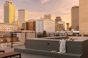 A rooftop terrace with a seating area, a hot tub, and a city skyline view. - Schaeffer Hotel (New Orleans)