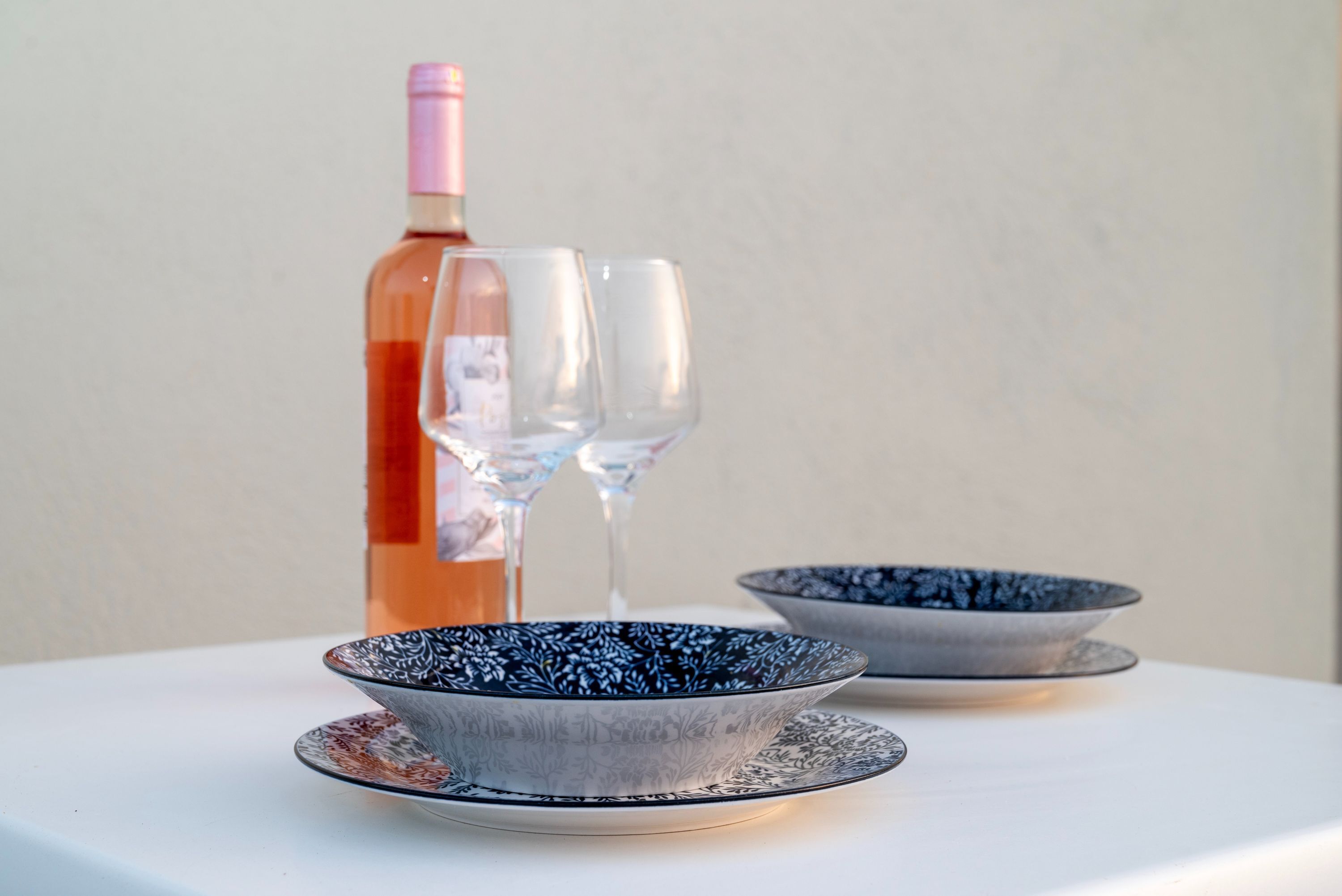 Una mesa con dos cuencos, una botella y dos vasos.