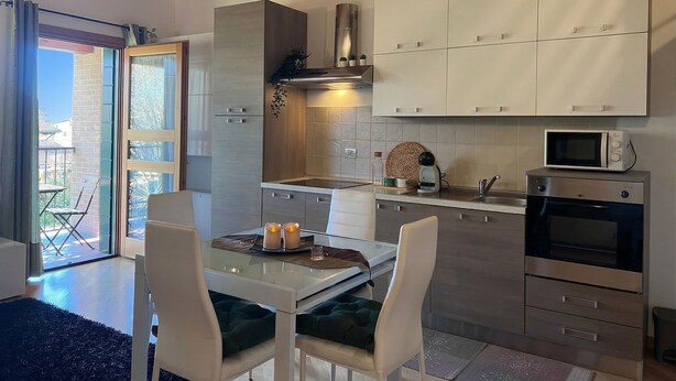 A modern kitchen with white cabinets, a microwave, and a built-in oven. - Venezia Golf Resort | Terrace & Free Parking (Martellago)