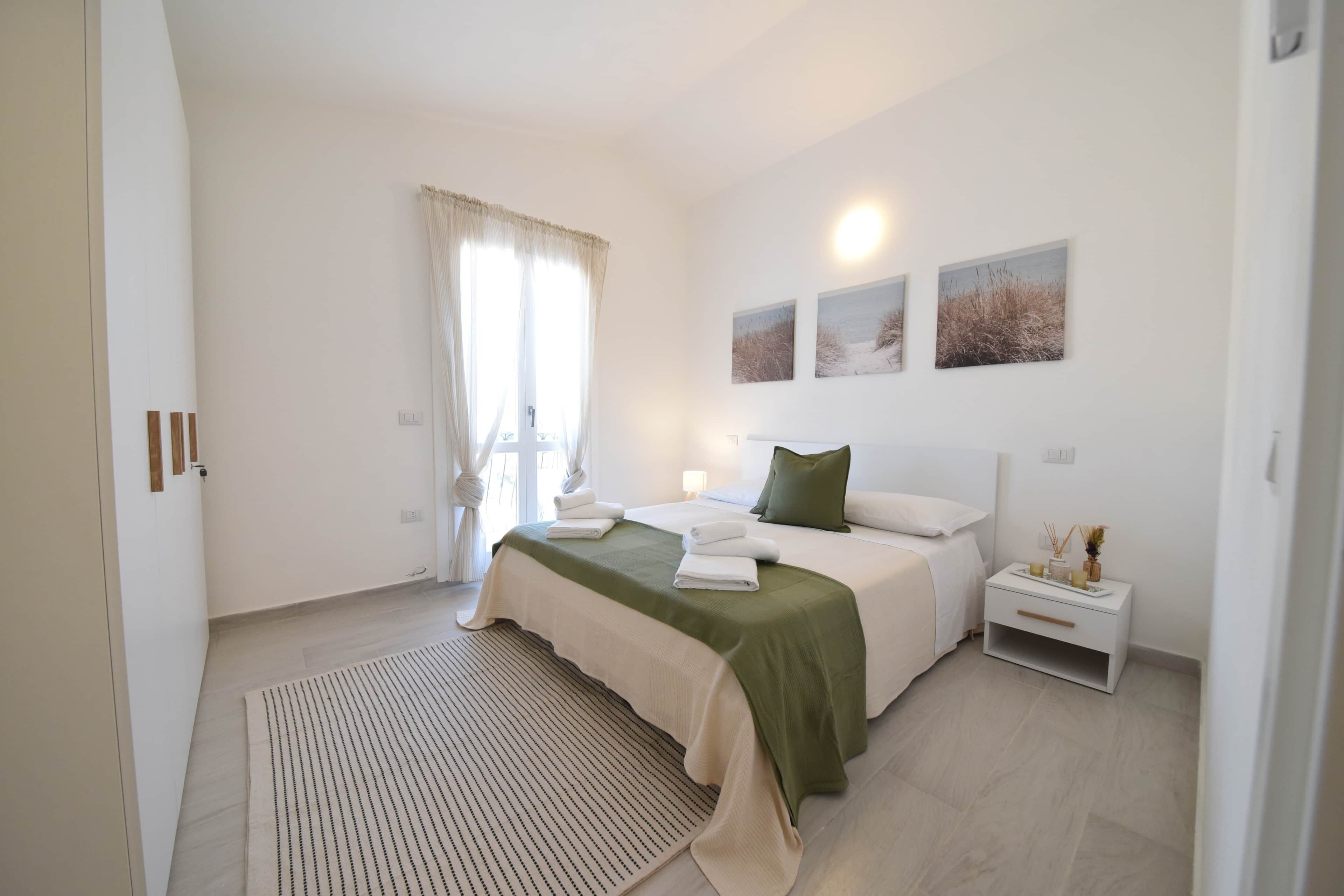 Une chambre à coucher avec un lit, une table de chevet et une fenêtre avec des rideaux.
