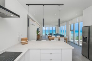 Een moderne keuken met een keukeneiland, een eethoek met uitzicht en een grote koelkast.