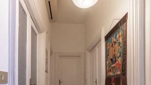 A hallway with wooden flooring, white doors, and a ceiling light fixture. - Casa Anna - Vatican City  (Rome)