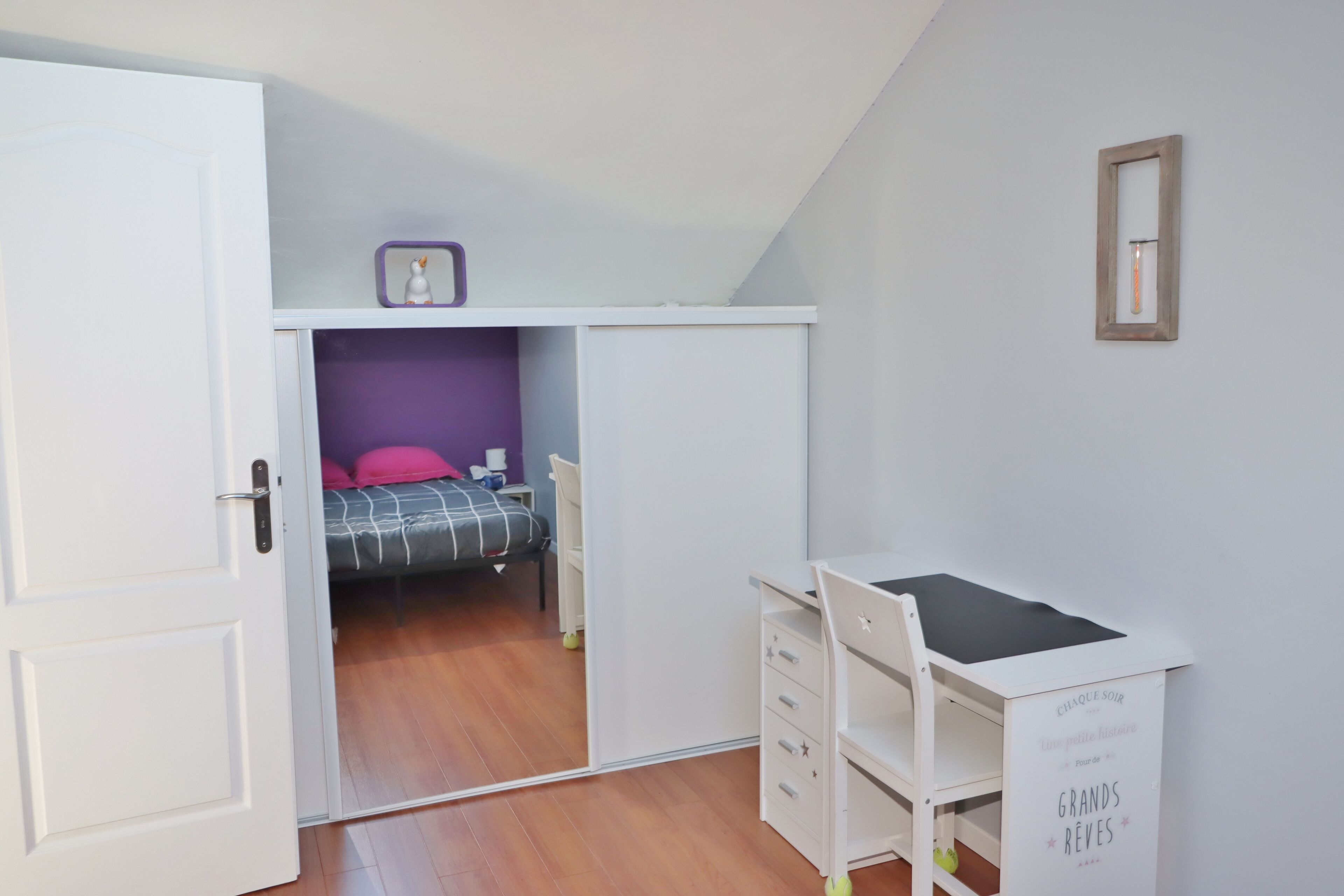 Un dormitorio con cama, escritorio y armario.