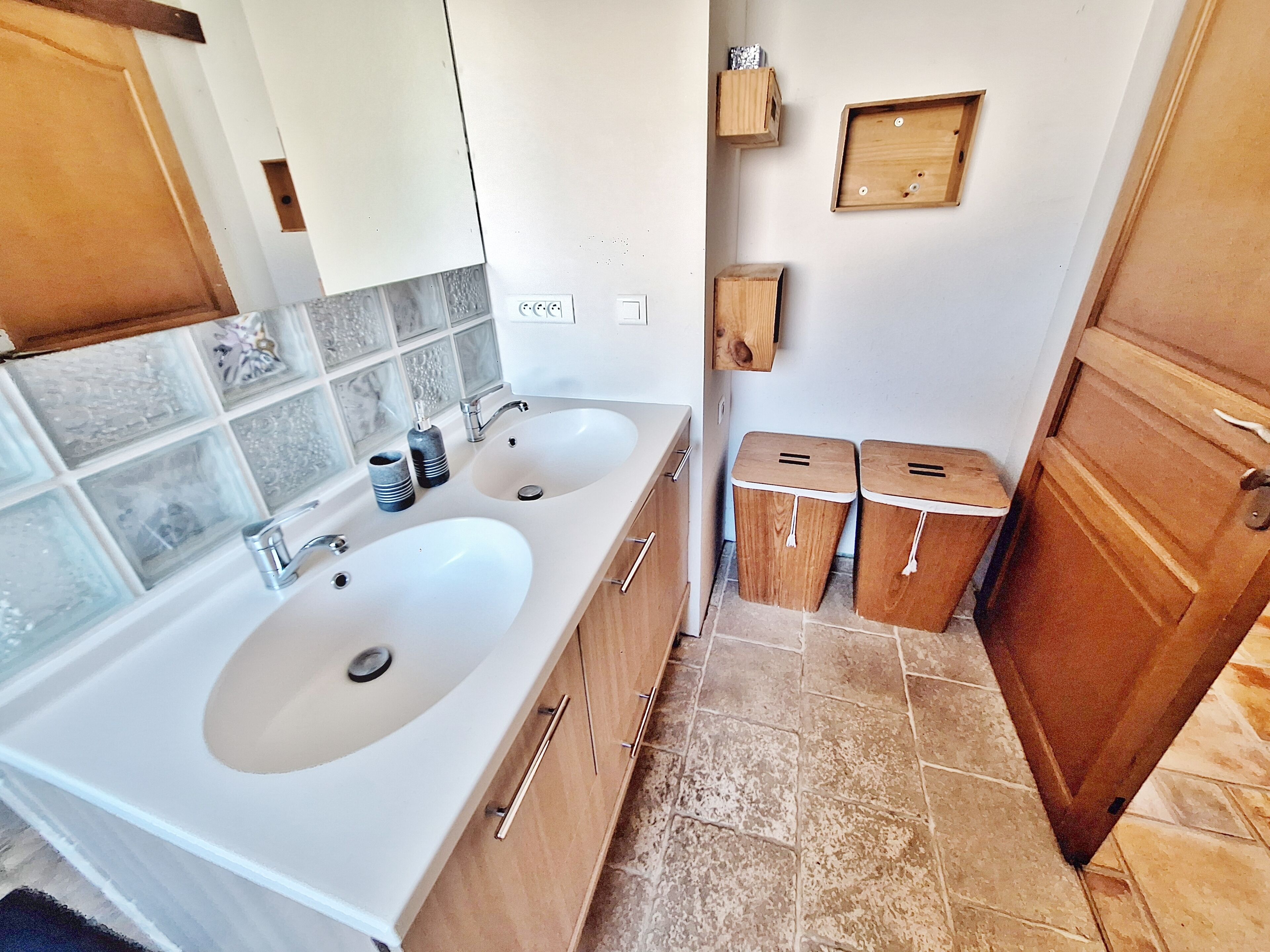 A bathroom with two sinks, a mirror, a towel rack, and a wooden door.