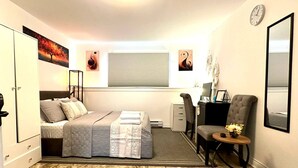 A bedroom with a bed, bedside table, chair, desk, and a window with blinds. - Room-saint John - Wi-fi - 4mins Regional (Saint John)