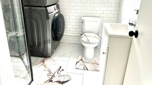 A bathroom with a washing machine, toilet, and a sink. - Room-saint John - Wi-fi - 4mins Regional (Saint John)