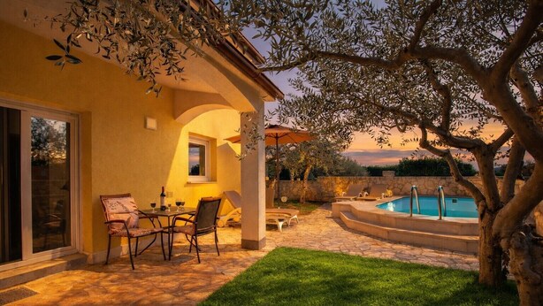 Um pátio com piscina, área de estar ao ar livre e vista para a piscina.