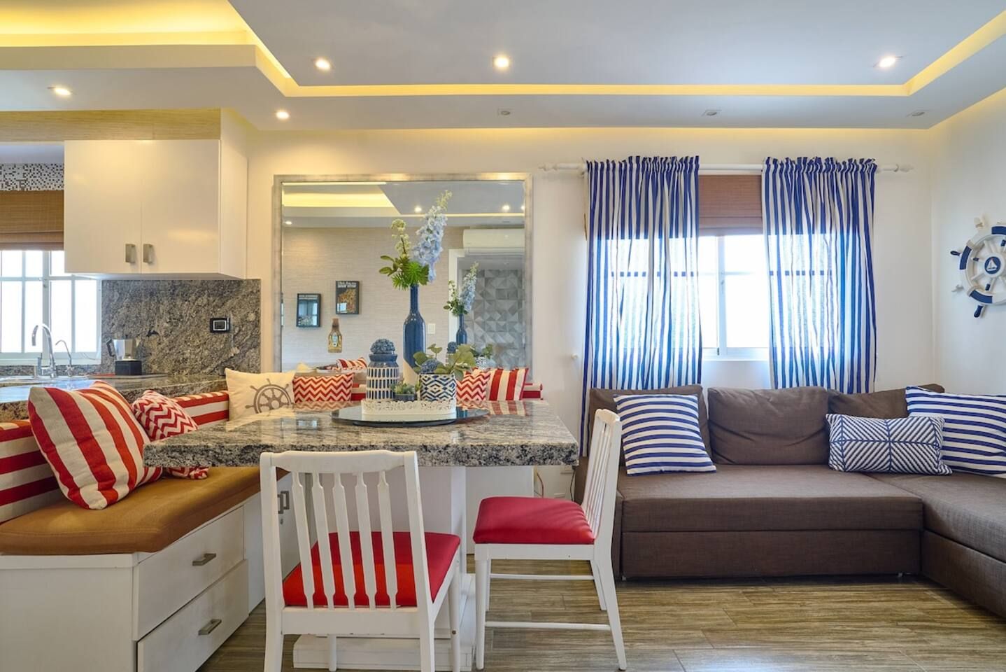 A modern living room with a sofa, chairs, and a dining area.