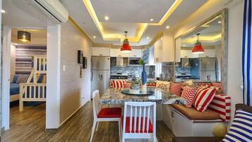 A modern kitchen with a central island, seating area, and a dining table.