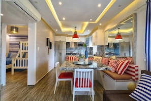 A modern kitchen with a central island, seating area, and a dining table.