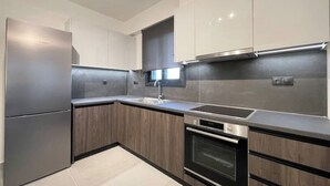 Una cucina moderna con elettrodomestici in acciaio inossidabile, mobili in legno e un piano di lavoro elegante.