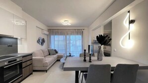 Una cucina moderna con zona pranzo, divano e tavolo con sedie.