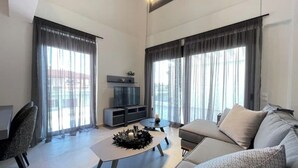 Uma sala de estar moderna com sofá, mesa de centro e rack para TV.