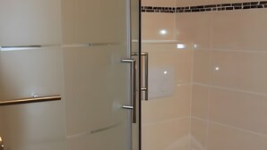 Ein Badezimmer mit Duschkabine, Toilette und Handtuchhalter.