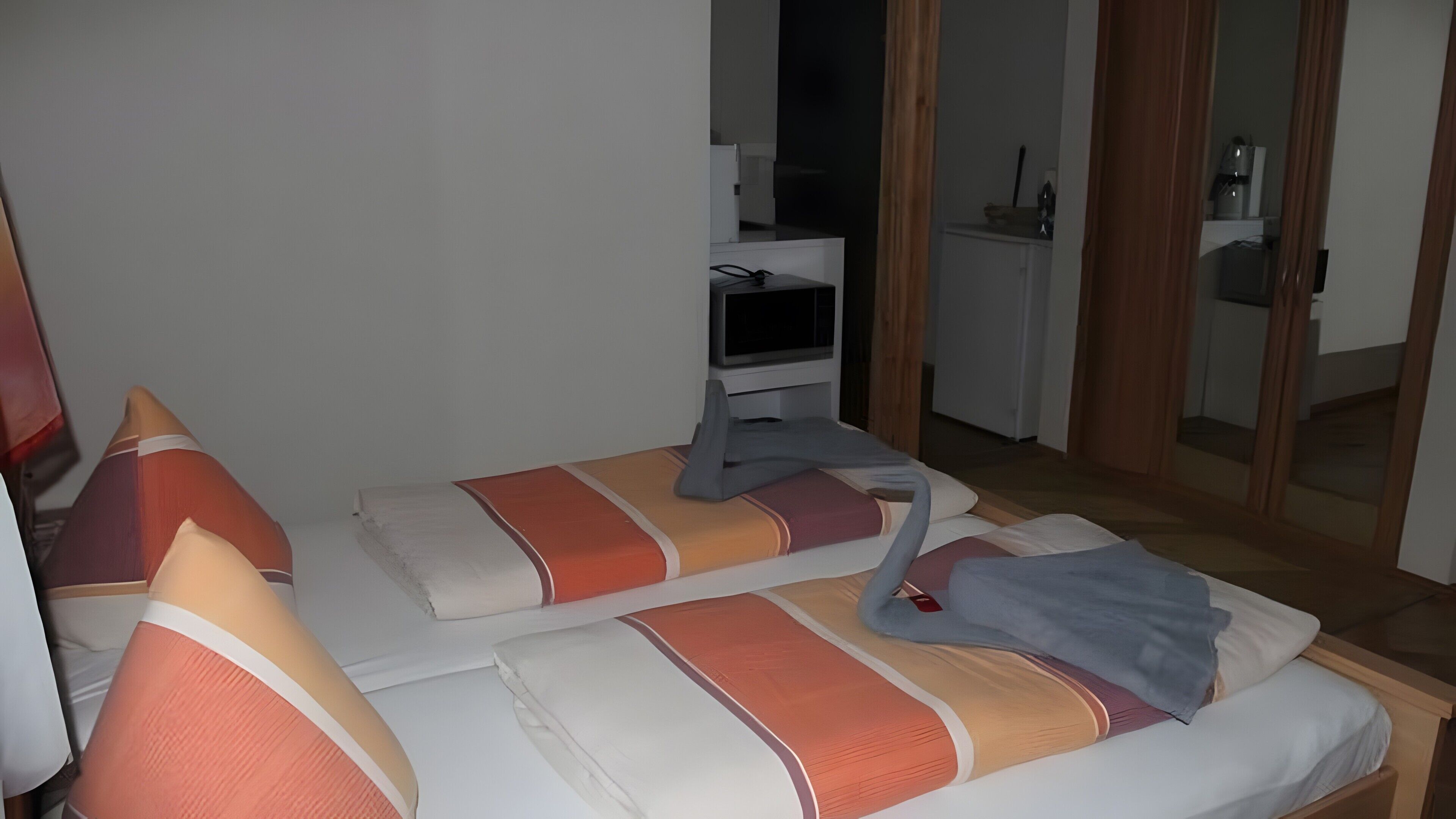A hotel room with a bed, a television, a desk, and a mirror.