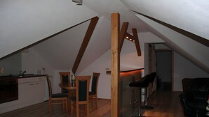 A loft-style room with a kitchen, dining area, and a bar. - Holiday Apartment for 2 People (60 m²) in Sehmatal (Sehmatal)
