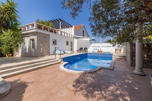 A modern villa with a swimming pool, outdoor seating, and a pergola. - Luxury Garden Villa 50m from the Beach (Sutivan)