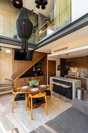 Une cuisine moderne dotée d’un îlot central, de meubles en bois et d’un téléviseur à écran plat.