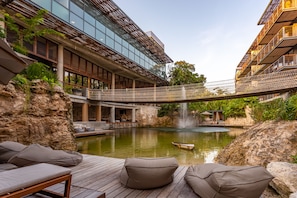Un hôtel moderne doté d’une piscine, d’un espace extérieur aménagé et d’un pont.