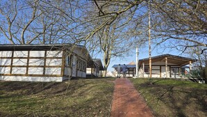 Un chemin menant à un bâtiment de style architectural traditionnel, sous un ciel dégagé, avec des arbres sans feuilles.