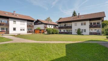 Ein Wohngebäude mit Innenhof, mehreren Balkonen und blauem Himmel.
