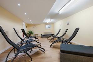 Una habitación con sillones reclinables, una mesita y una planta en maceta.