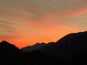 Vuorijonon siluetti auringonlaskun taivaalla.