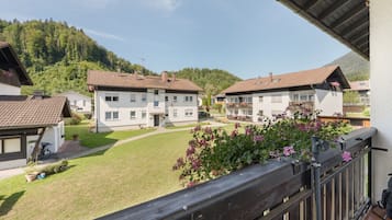 Ein Wohngebiet mit mehreren zweistöckigen Häusern, einem gepflegten Rasen und einer Bergkulisse im Hintergrund.