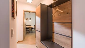 Ein modernes Interieur mit einem Holzschrank, einem Spiegel und einem Essbereich im Hintergrund.