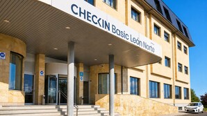 Ein Gebäude mit einem Schild, auf dem 'CHECKIN Basic León Norte' steht, und einem überdachten Eingang.