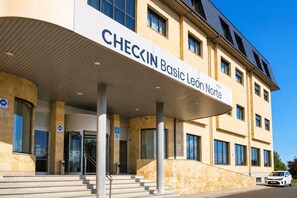 Ένα κτίριο με μια πινακίδα που γράφει «CHECKIN Basic León Norte» και μια σκεπαστή είσοδο.