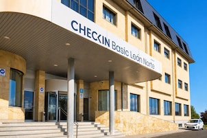 Un edificio con un letrero que dice 'CHECKIN Basic León Norte' y un acceso cubierto.