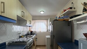 A kitchen with a stove, refrigerator, and cabinets. - Your refuge in the Historic Center of Quito (Quito)