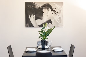 A dining table set with plates, glasses, and a vase with a plant. - Bright apartment at Spanish Steps (Roma)