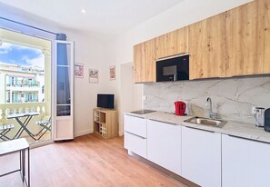 Eine moderne Küche mit Holzausstattung, einer integrierten Mikrowelle und einer Marmorarbeitsplatte.