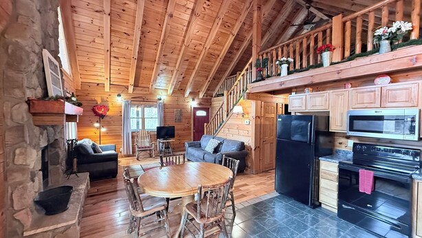L’intérieur d’une cabane en bois comprend un coin repas, une cuisine et un escalier menant à une mezzanine.
