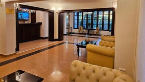 A lobby with a reception desk, seating area, and large windows. - Hotel Royal Plaza (Timișoara)