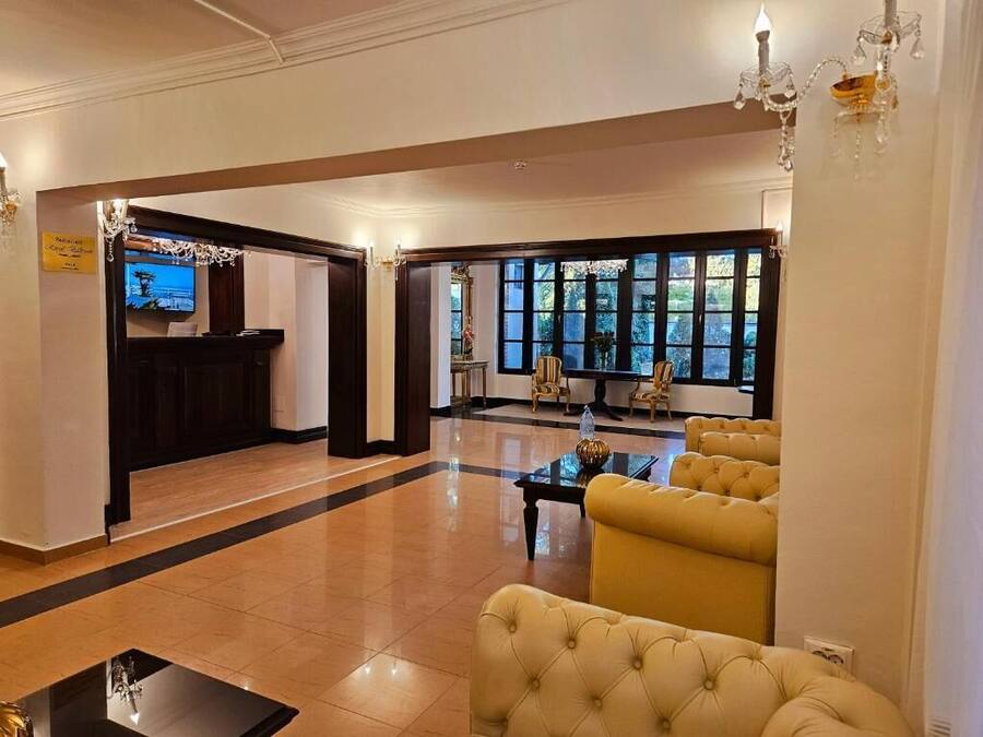 A lobby with a reception desk, seating area, and large windows.