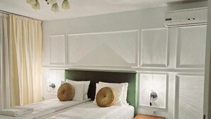 A double bed with white linens, a green headboard, two bedside lamps, and a small wooden nightstand. - Hotel Royal Plaza (Timișoara)